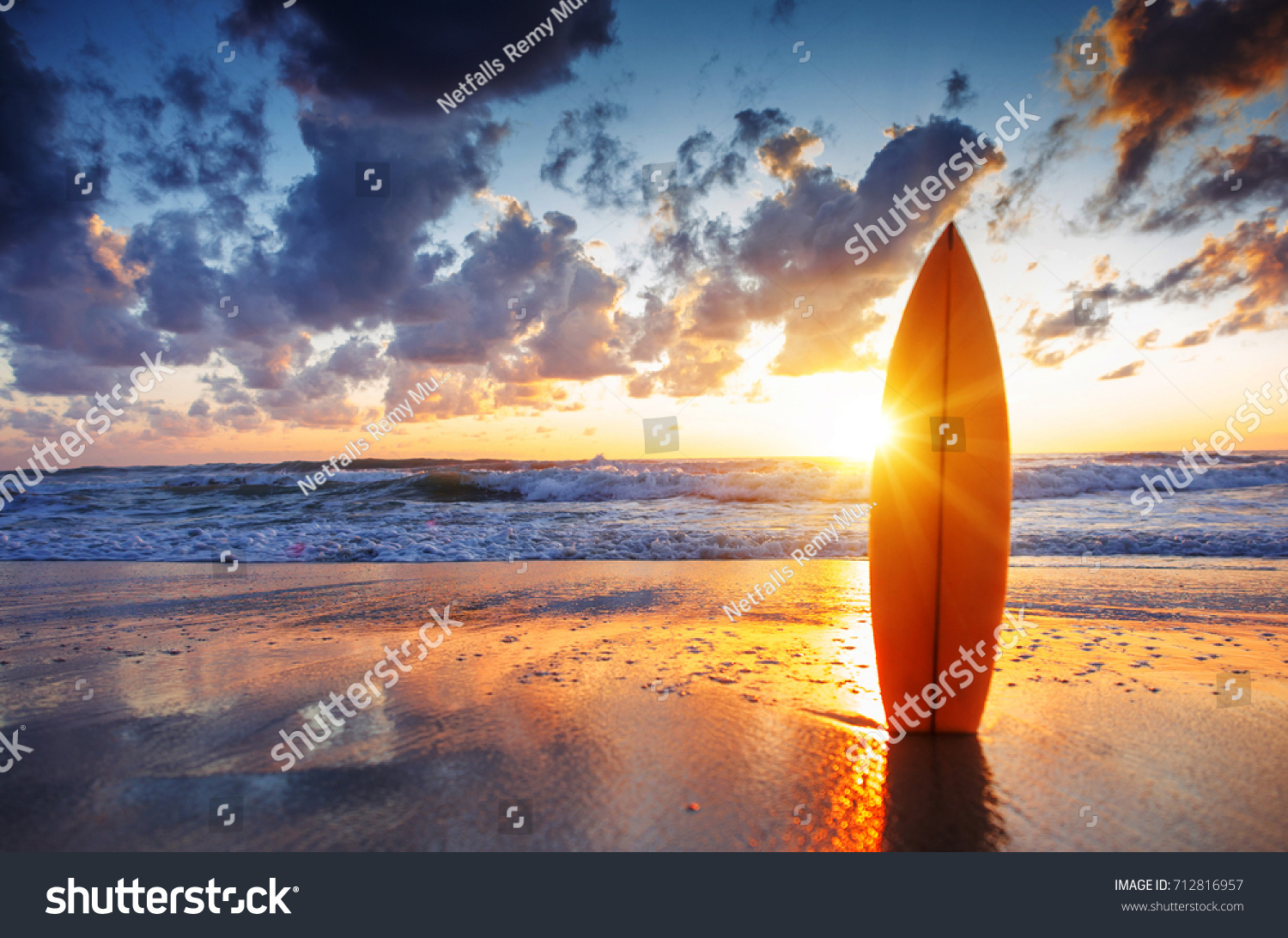 Surfboard on the beach at sunset