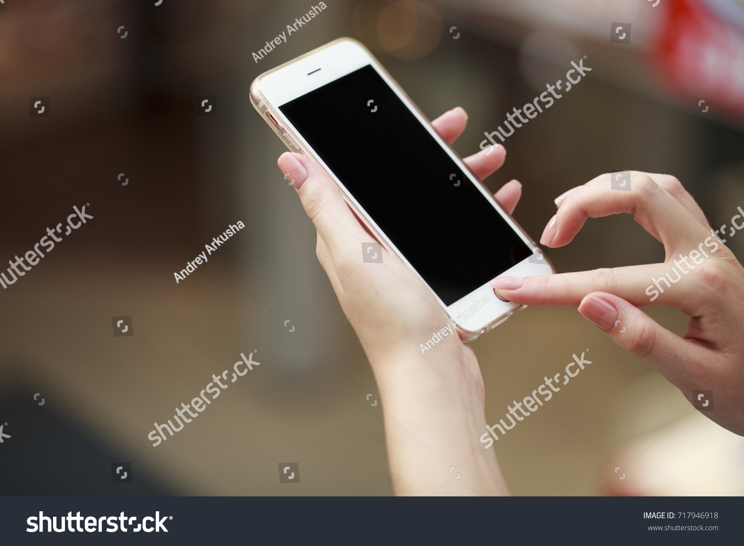 Beautiful female hands holding a mobile phone  indoor