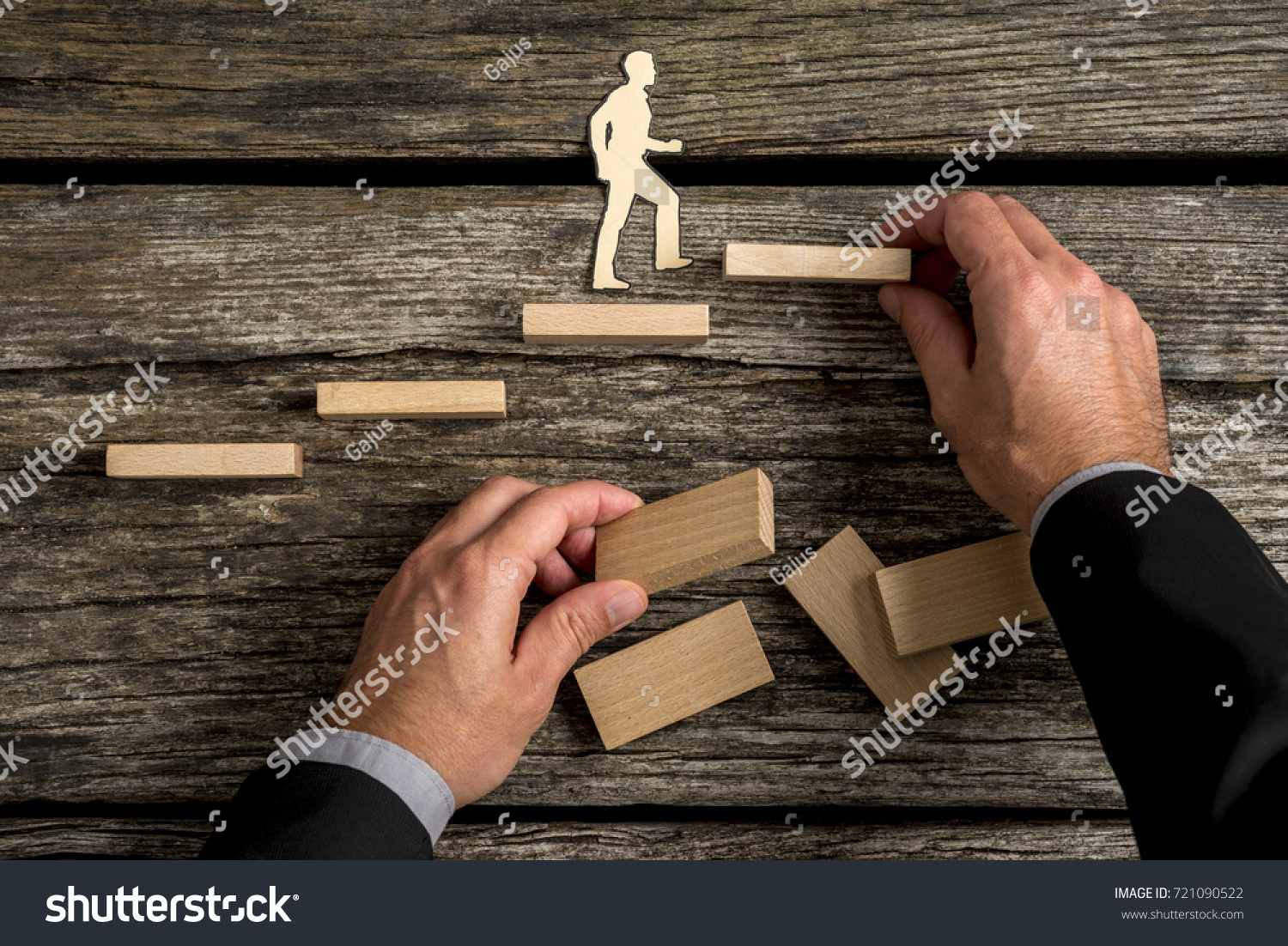 Silhouette cutouts of a man walking up steps  while the hand of other businessman building stairs for him in a conceptual image of personal and career promotion.