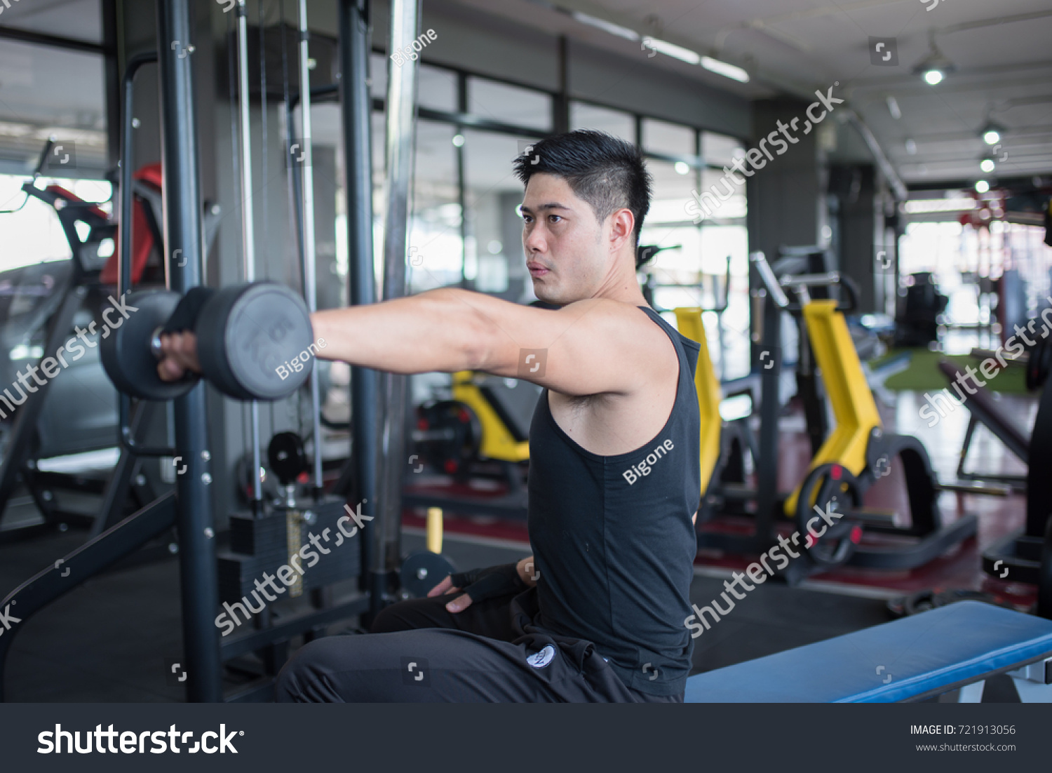 Young adult  man working out in gym used dumbbell