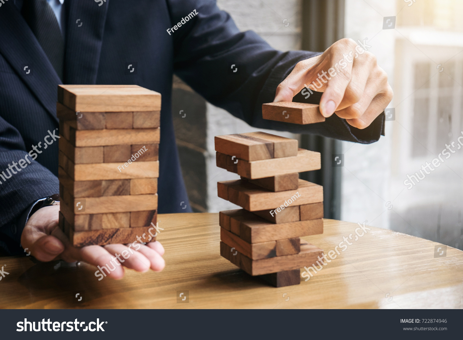 Alternative risk concept  plan and strategy in business  Young intelligent businessman playing the wood game  hands of executive cooperate placing wood block on the tower  Collaborative management.