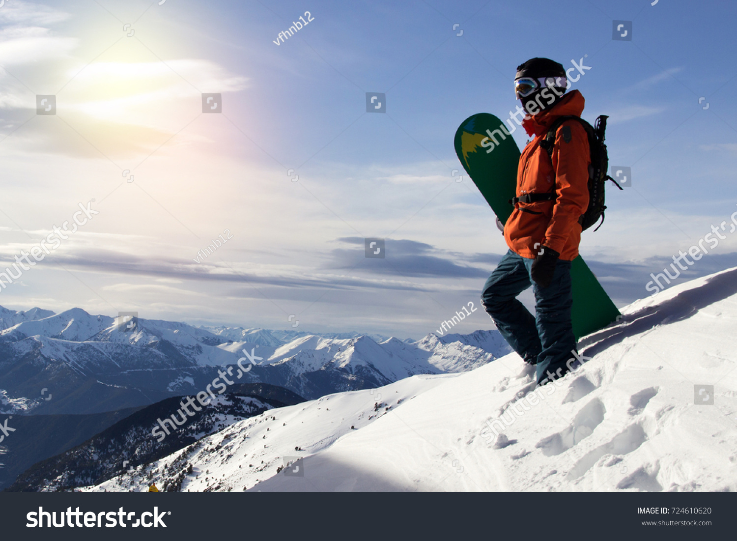 Small snowboarder on blue sky backdrop.
