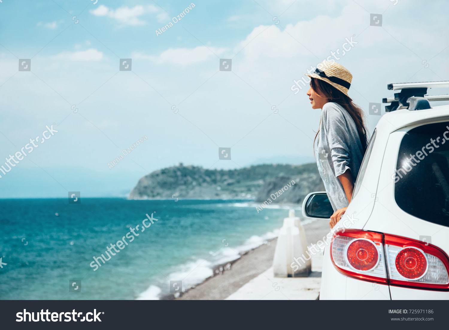 Rear view of pre teen child in car over sea view on summer roadtrip to the beach 