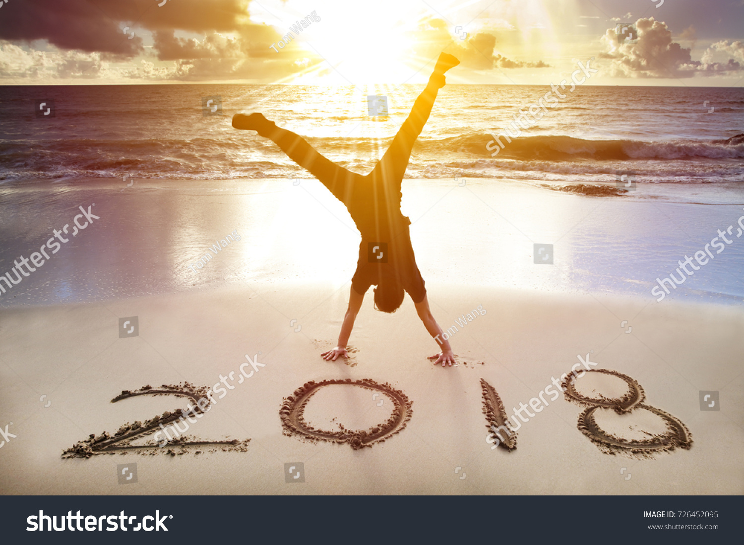  man handstand on the beach.happy new year 2018 concept
