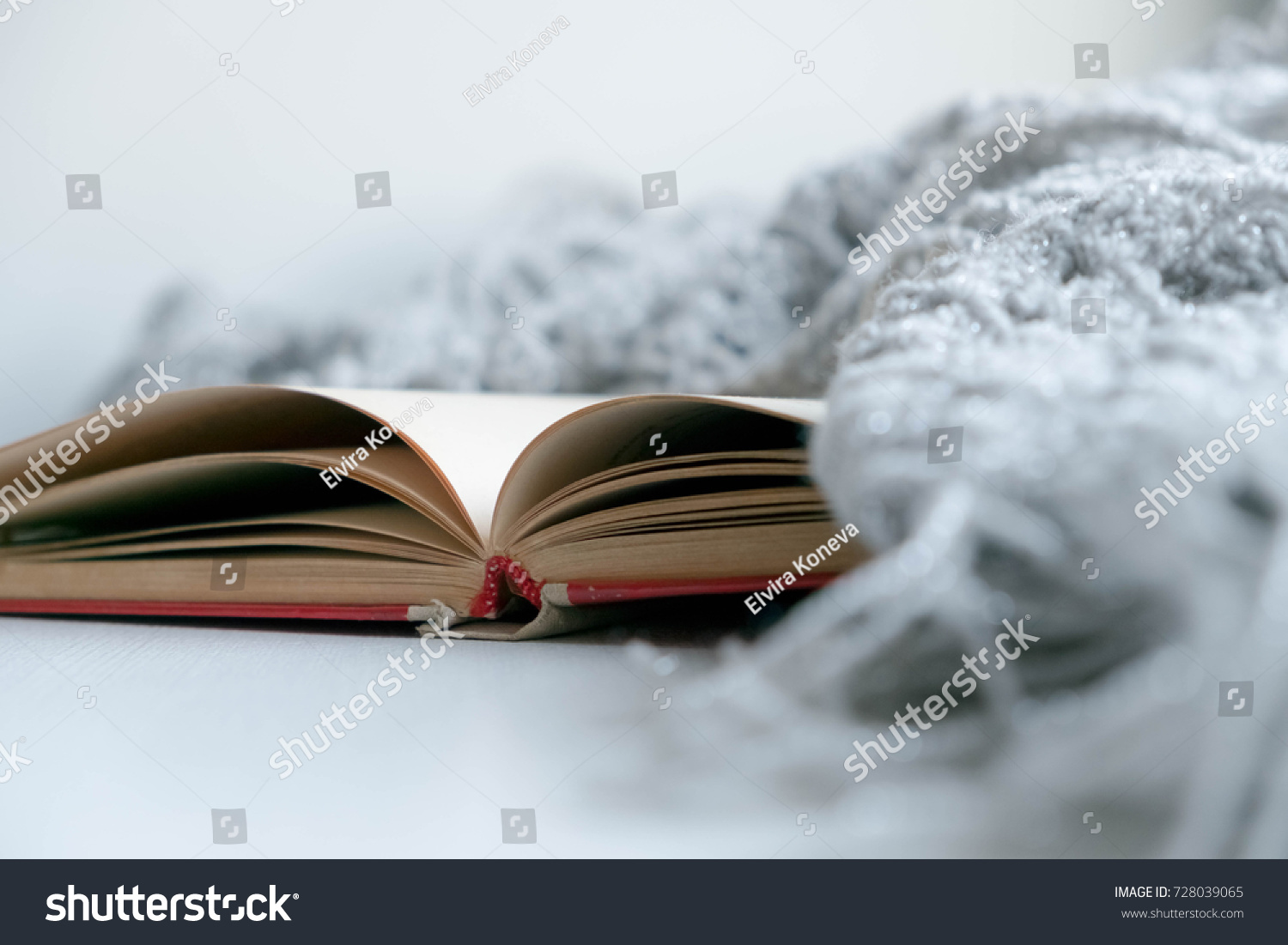 Cozy winter still life: opened book. Warm and comfy autumn or winter concept. sweater. Reading relaxing cold fall weather at home. Winter holidays Christmas time concept free copy space