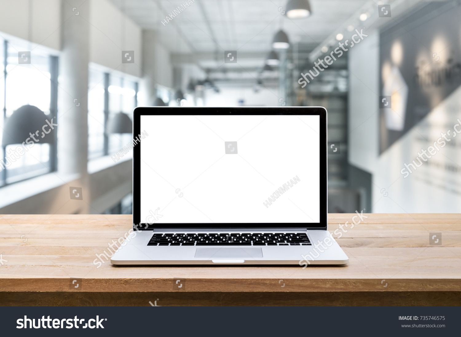 Modern computer laptop with blank screen on blur modern/contemporary hall backgrounds