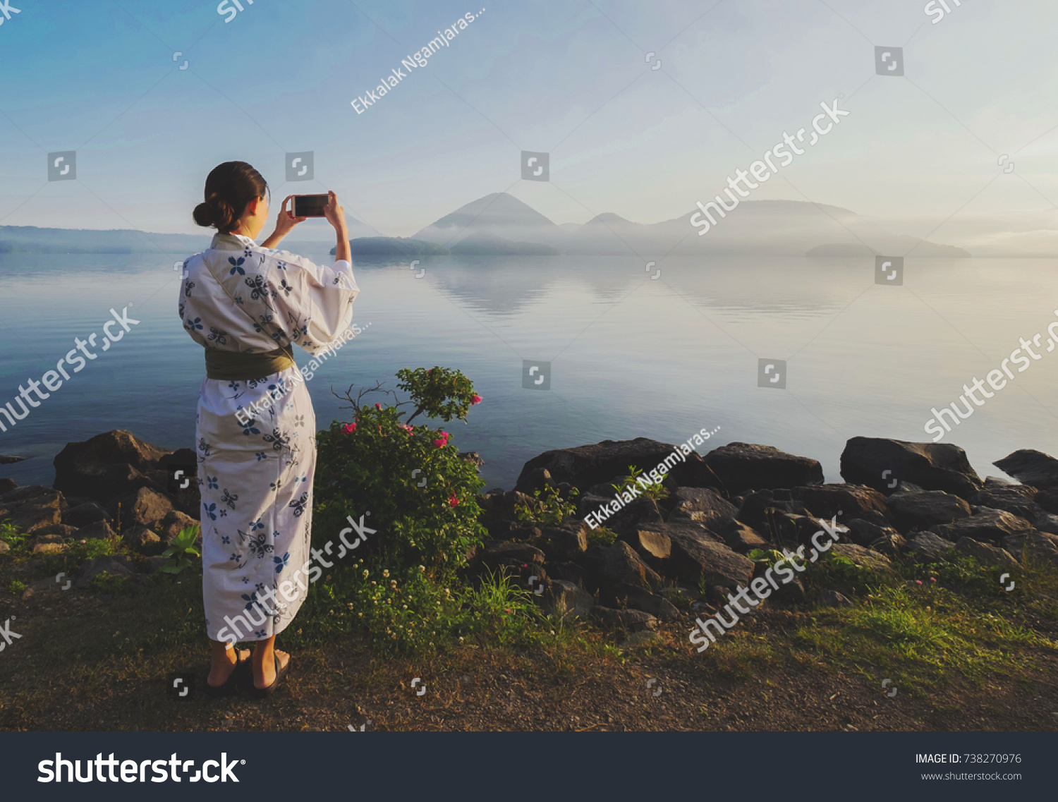 Beautiful Japanese girl use smart phone taking photo lake toya view  toyako  hokkaido Japan at the morning  use filter