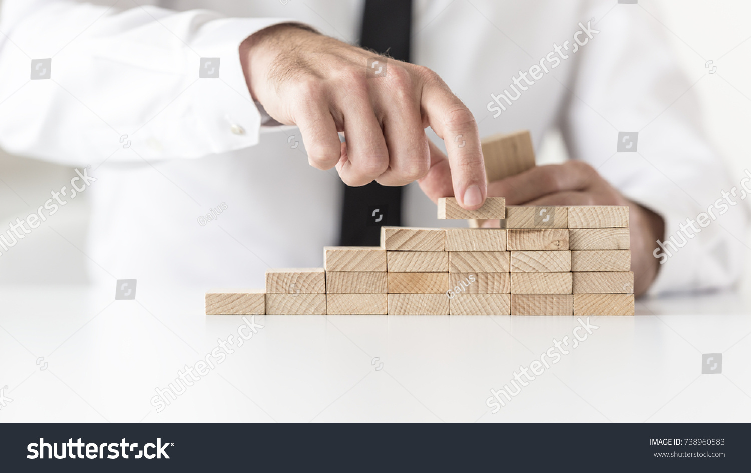Businessman in white shirt building a graph or ladder of success. Conceptual of business growth.