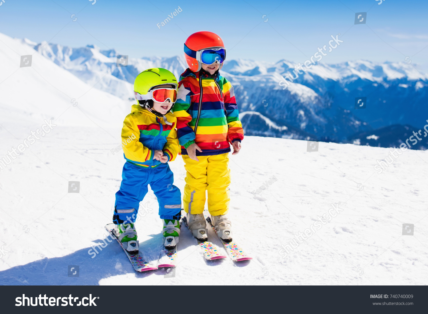 Child skiing in the mountains. Kid in ski school. Winter sport for kids. Family Christmas vacation in the Alps. Children learn downhill skiing. Alpine ski lesson for boy and girl. Outdoor snow fun.