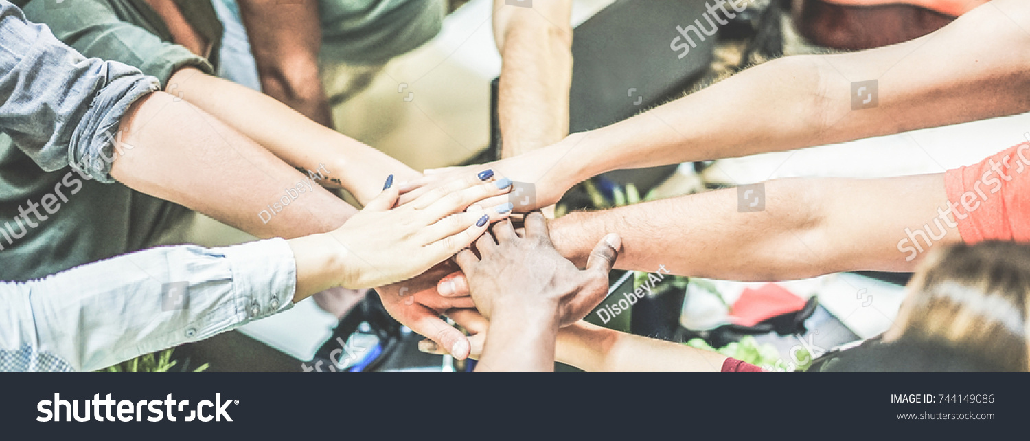 Work team stacking hands together for new startup project - Diverse culture people giving strength motivation to each others - Focus on blue nails woman hand - Power and human strongness concept