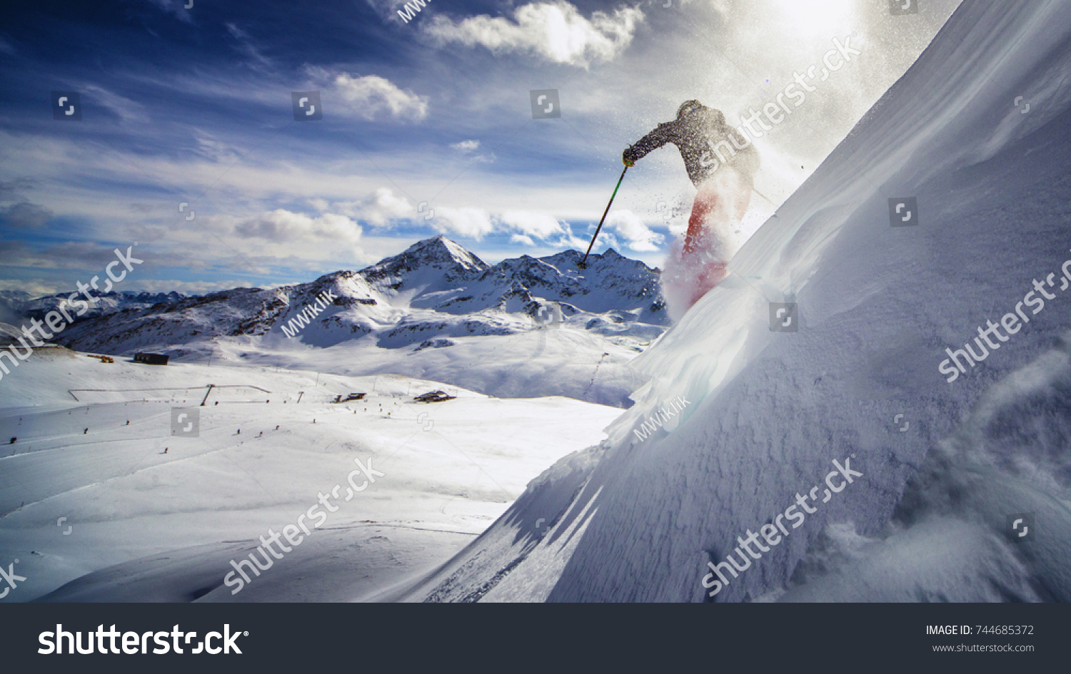 免费的滑雪者 沿着陡峭的斜坡滑雪 蓝天和山脉的良好背景