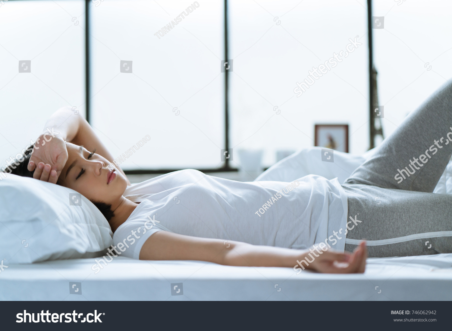 Asian girl is headache in bed.