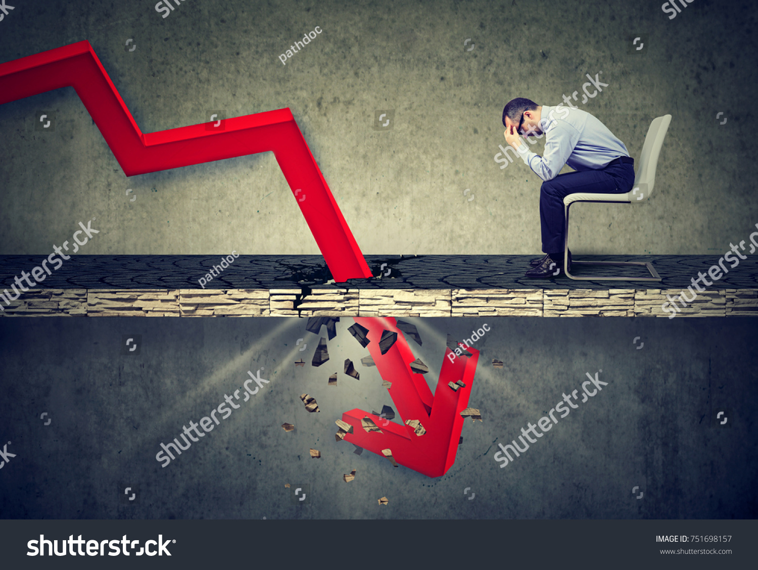 Depressed business man looking down at the falling red arrow going through a concrete floor. Fall and depreciation concept.