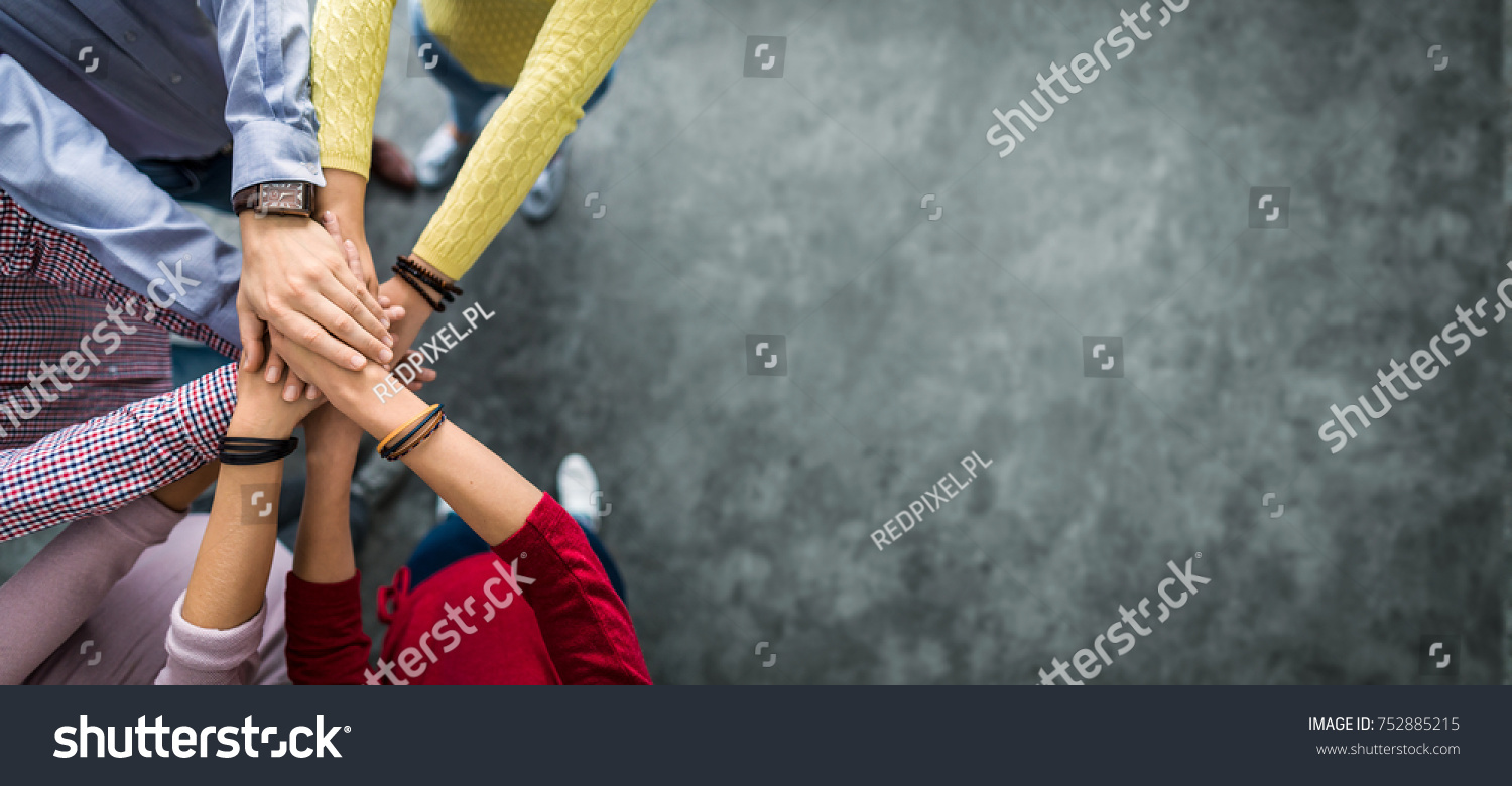 Close up top view of young business people putting their hands together. Stack of hands. Unity and teamwork concept.