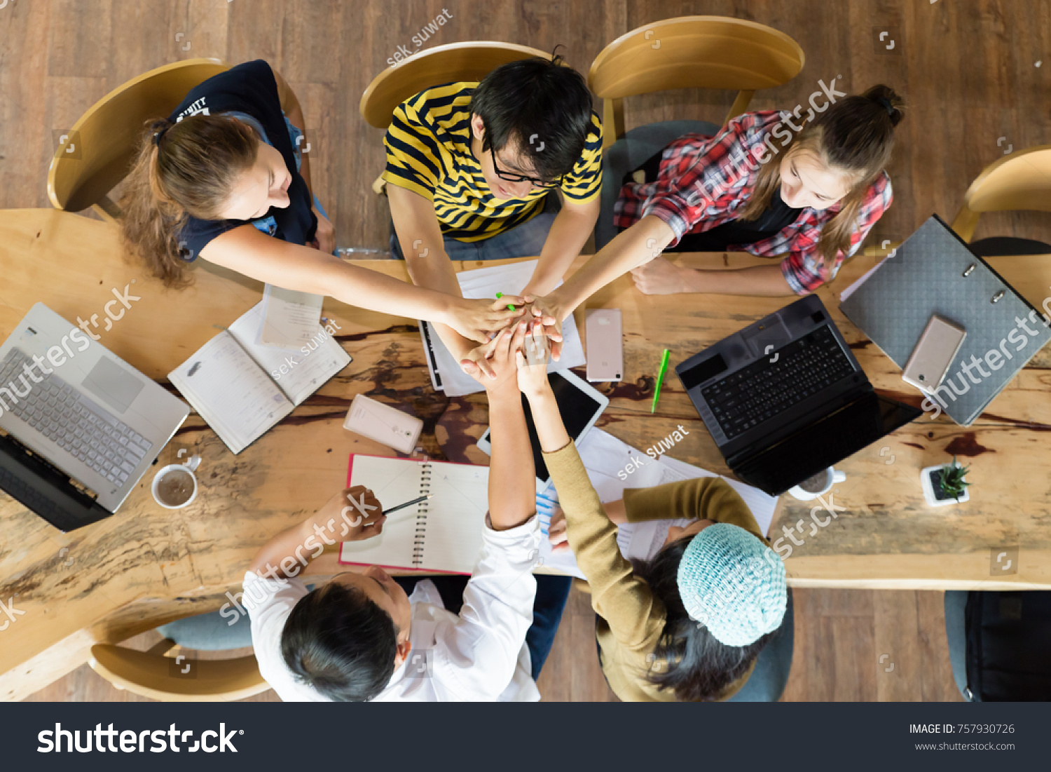 Group of young students in cooperation with their academic assignment. Top view shot of young people studying together around a table. students together at school table working homework and have fun.