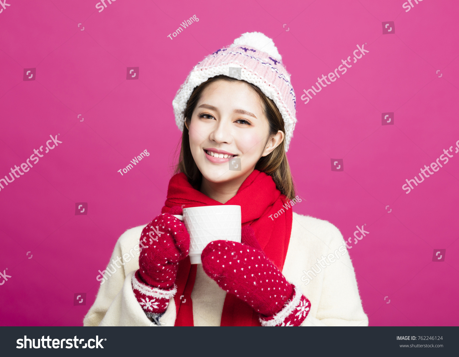 woman in warm sweater drinking a cup of hot tea
