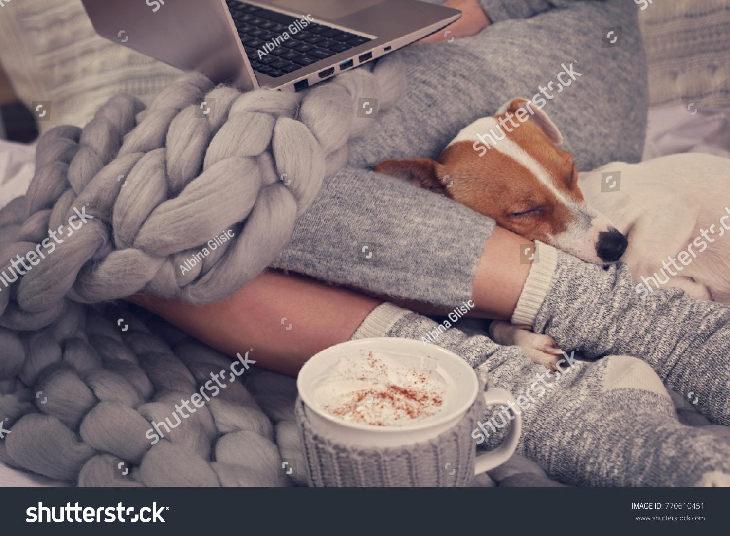 Cozy home warm blanket hot drink movie night. Dog sleeping on female feet. Relax carefree comfort lifestyle.