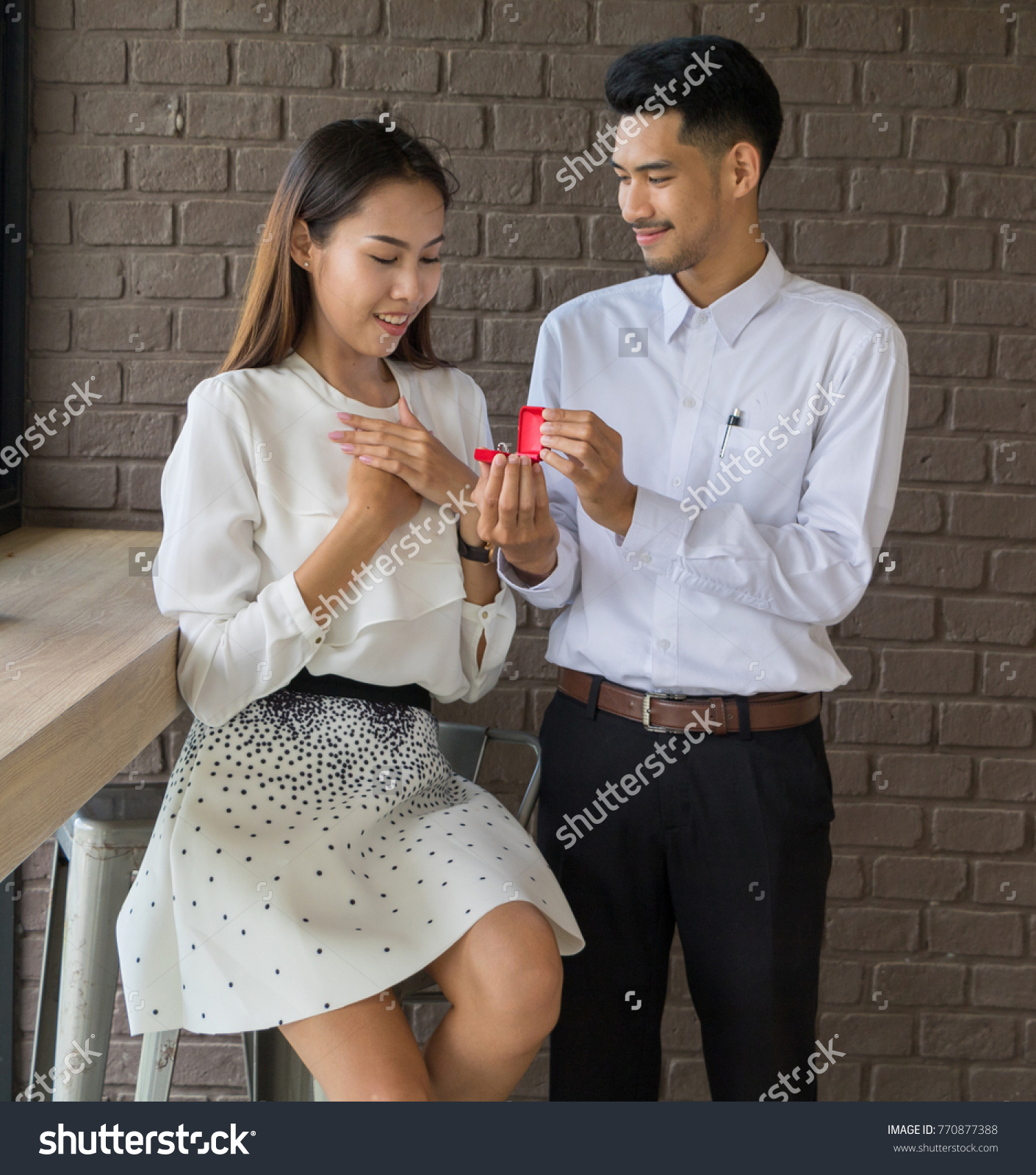 Asian young man hold a wedding ring box to get married in coffee shop.