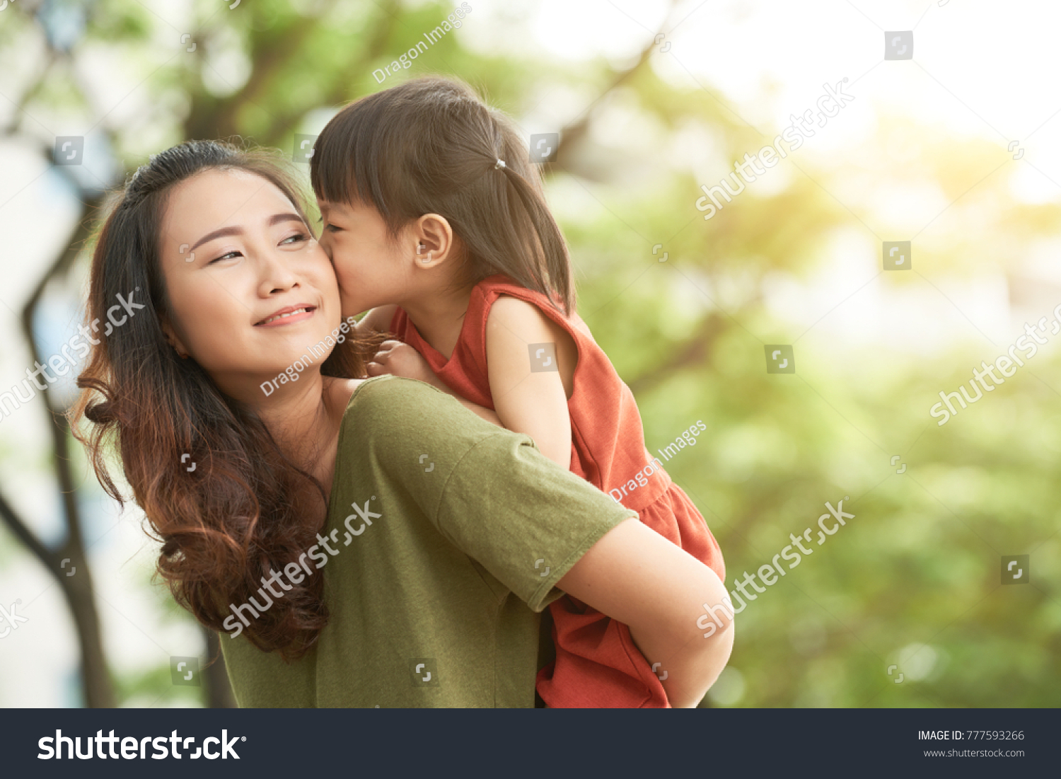 Girl kissing mother when she giving her piggyback ride