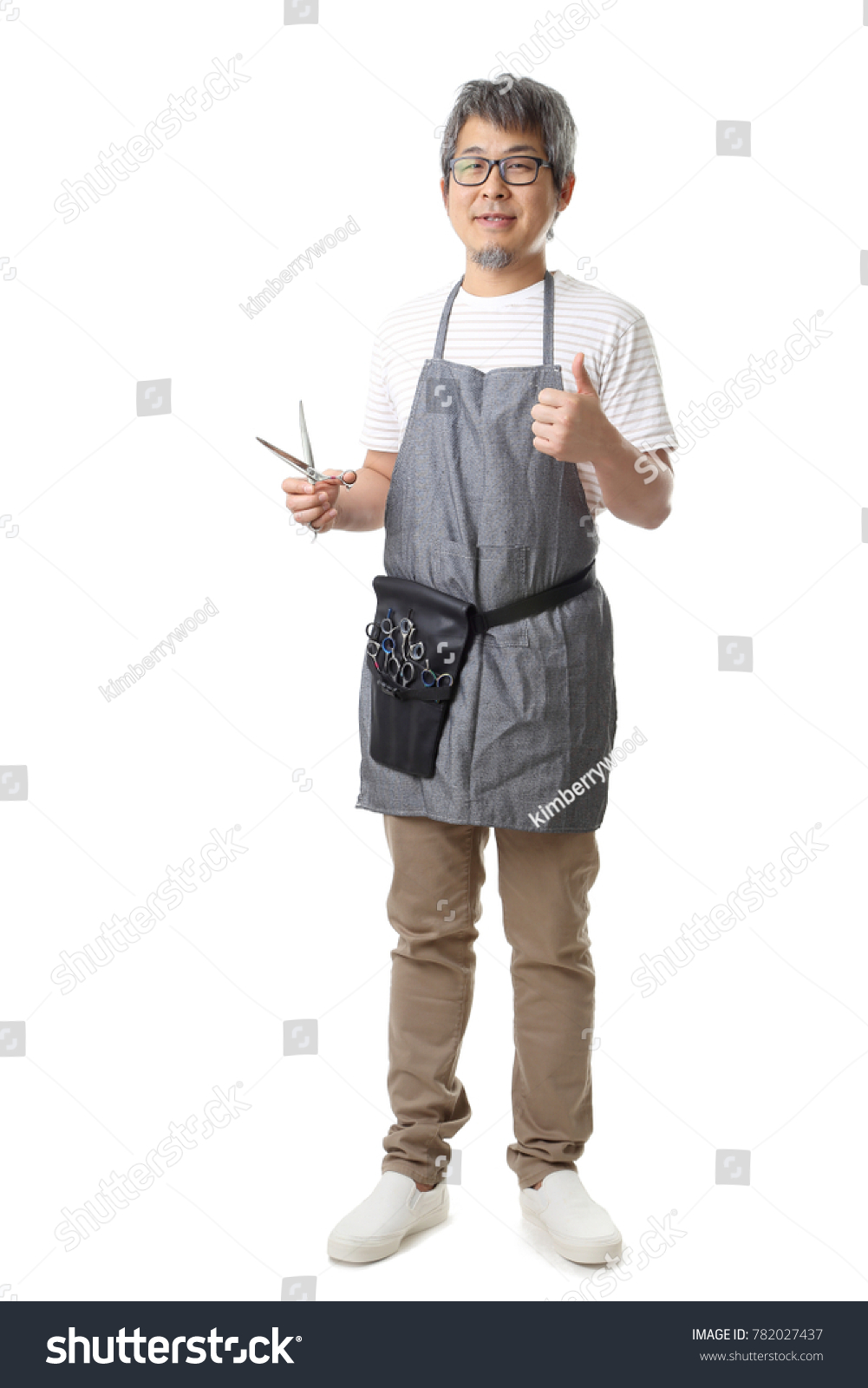 The Asian pet groomer standing on the white background.