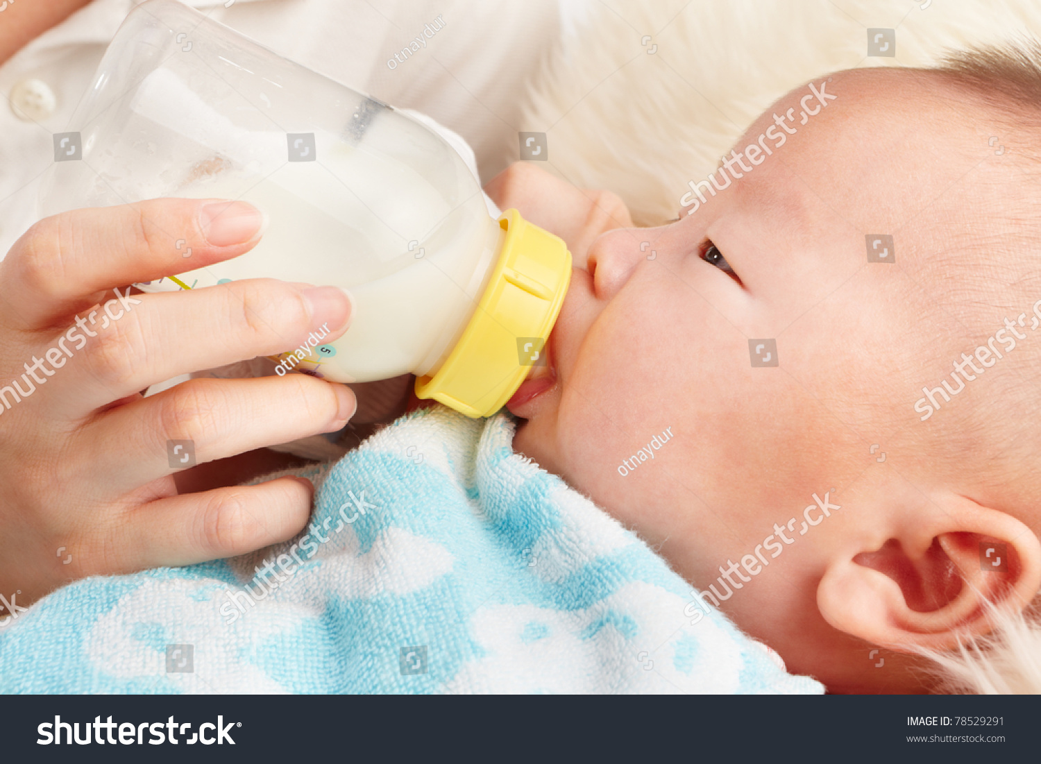 baby is feeding milk from baby's bottle