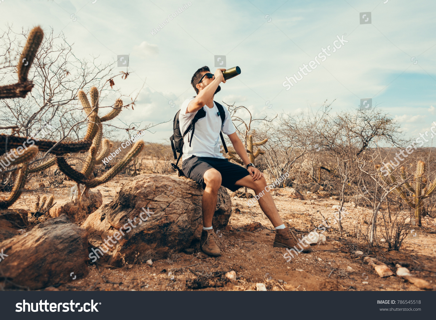 Tired hiker drinks water from a bottle
