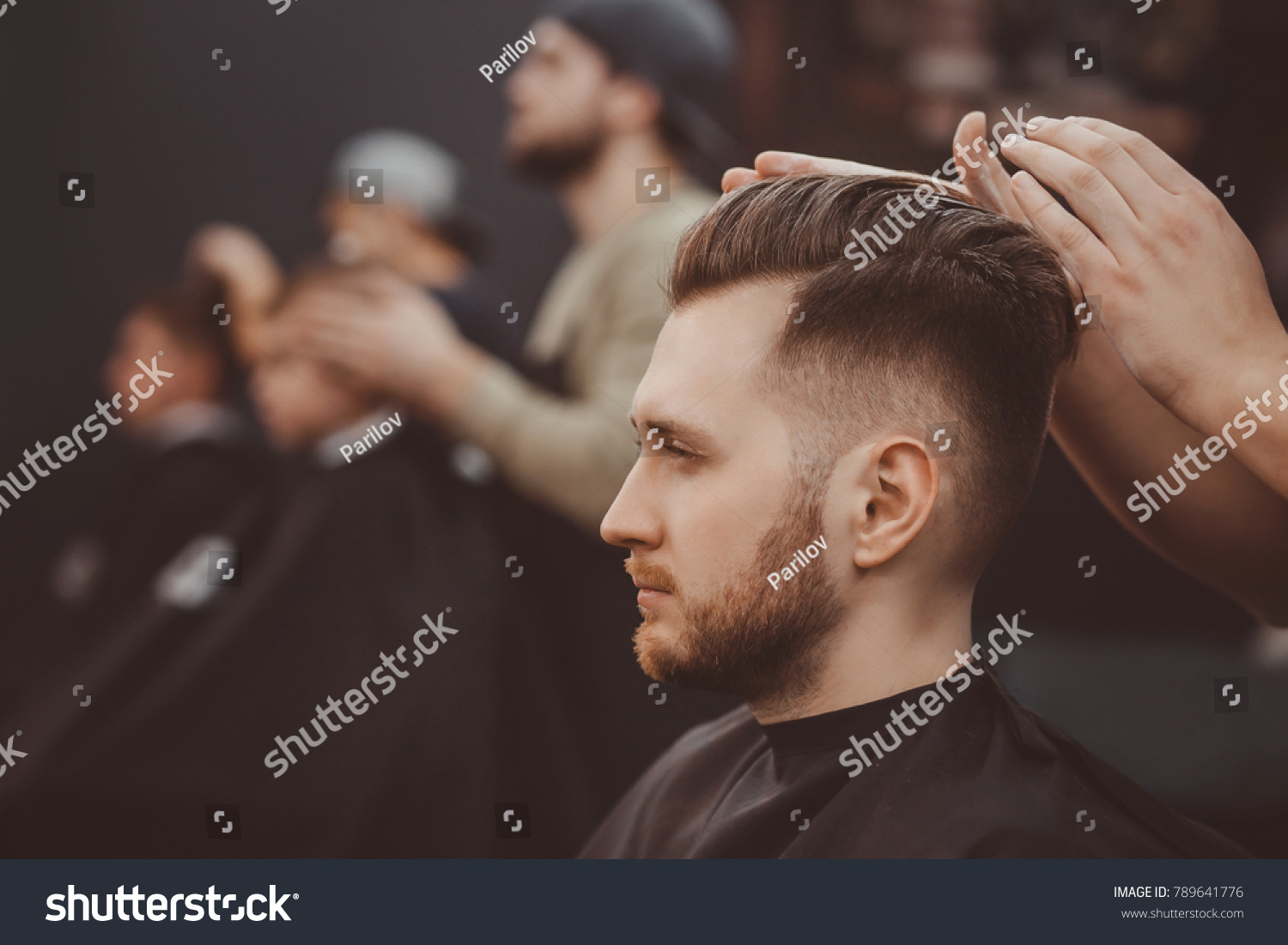 Barber shop. Man in barber's chair  hairdresser styling his hair