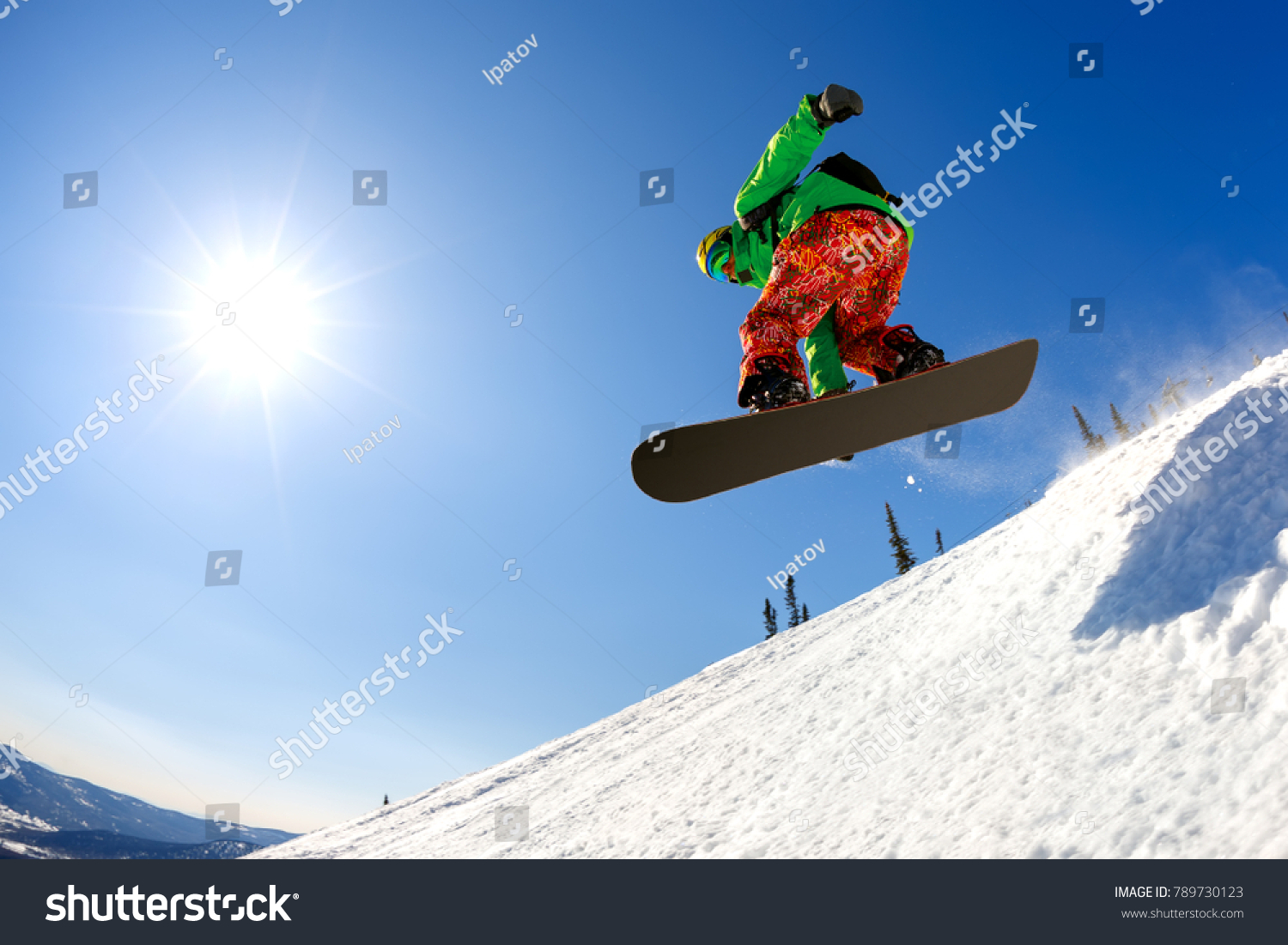 Snowboarder jumping through air with deep blue sky in background