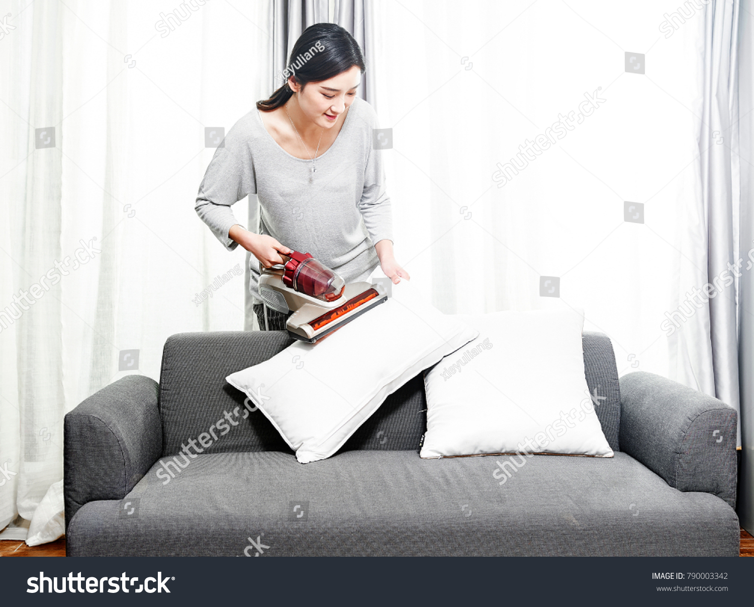 Housewives use a vacuum cleaner to clean the dust in the pillow