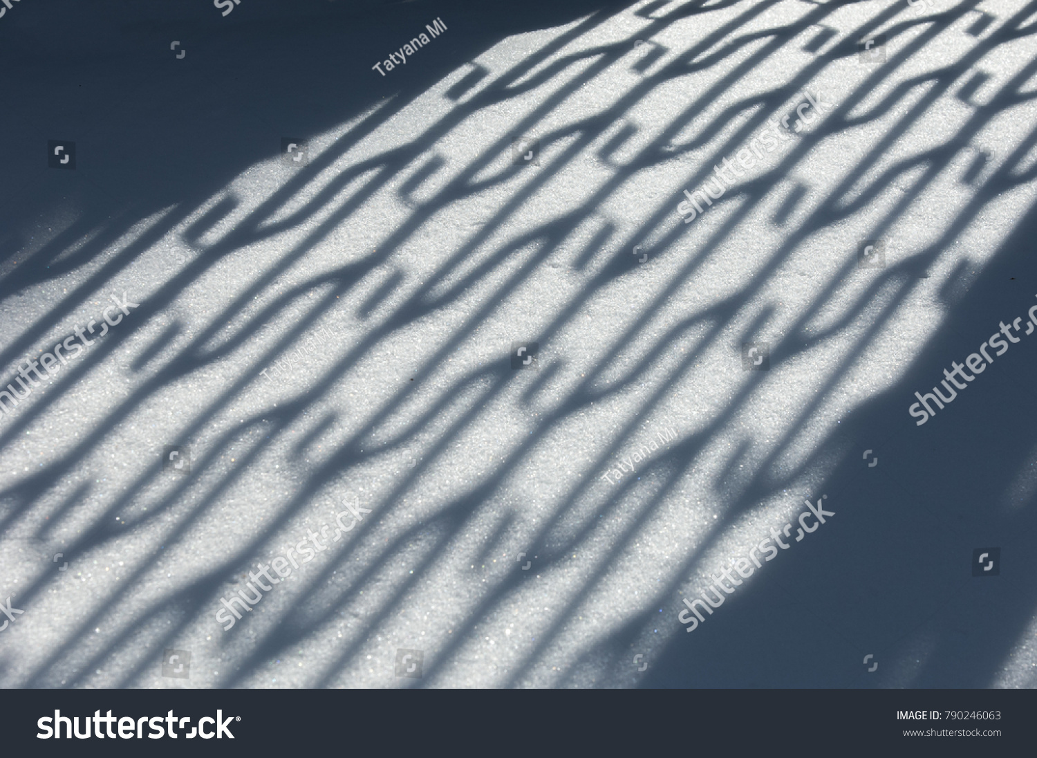 Winter landscape. Textural background. reflection of shadows on the snow with an artificial fence. shadow and light. Landscape City