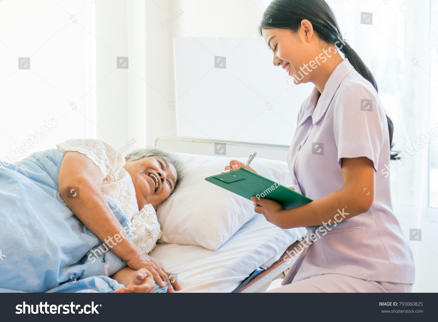 cheerful Asian nurse talking with elderly patient for monitoring and check up. nurse giving consoling to senior and encourage in the hospital.
