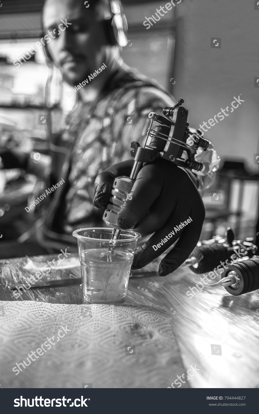 Hand of tattoo artist and a tattoo machine.