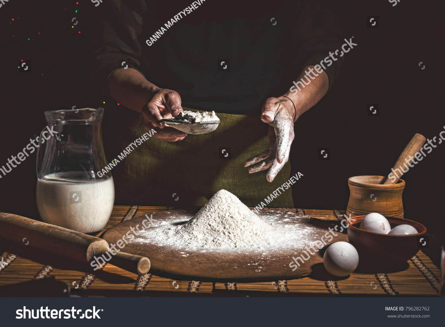 Bakery. Man preparing bread  Easter cake  Easter bread or cross-buns on wooden table in a bakery close up. Man preparing bread dough.