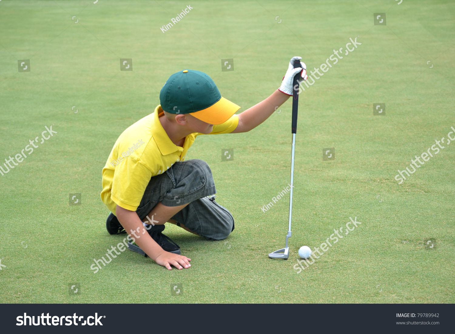 boy lining up a putt on the green