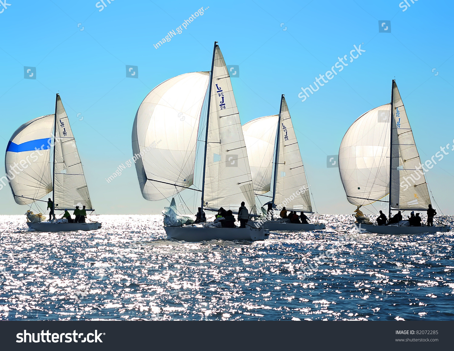 Sailing regatta in Greece: Four back-lighted boats with spinnakers open