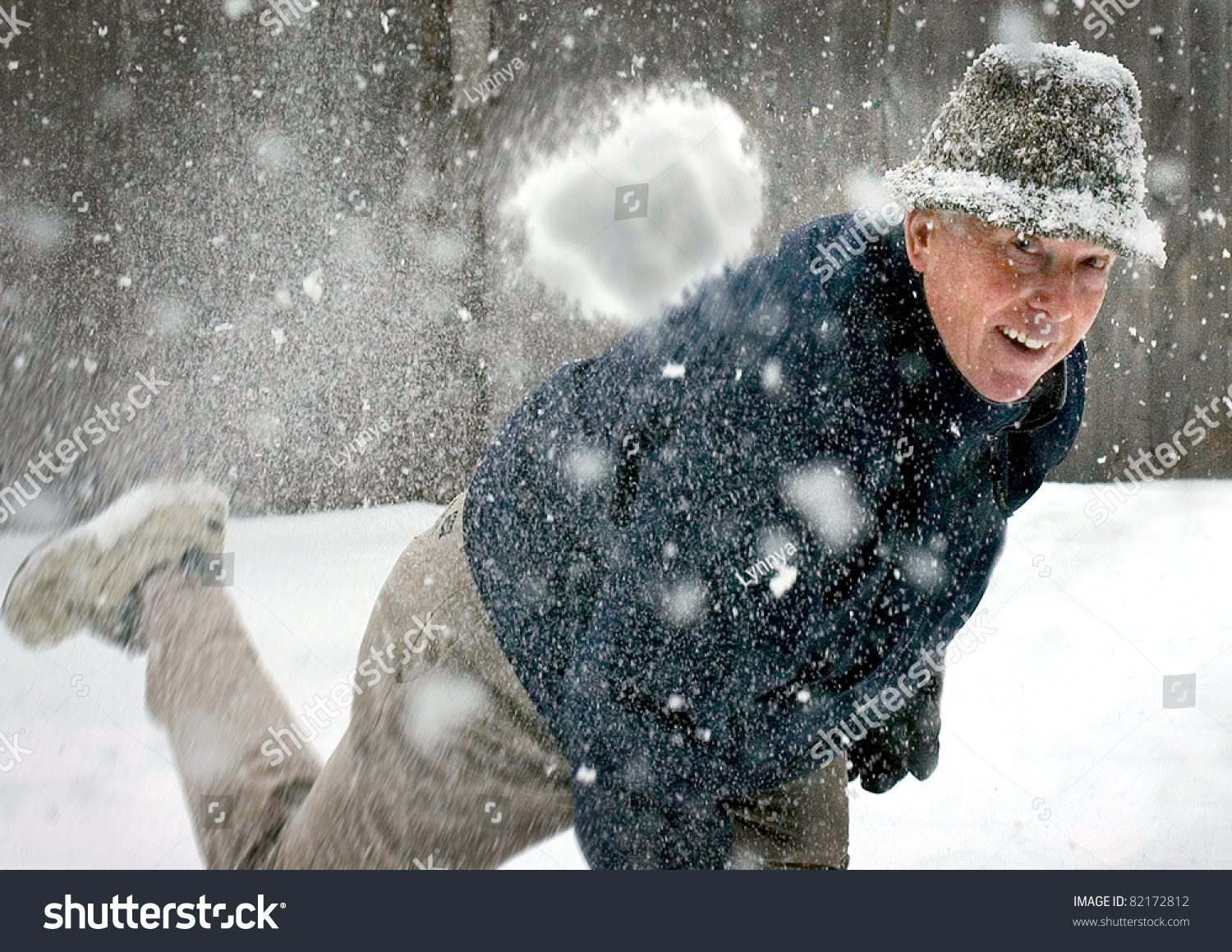 A senior man throwing a snowball