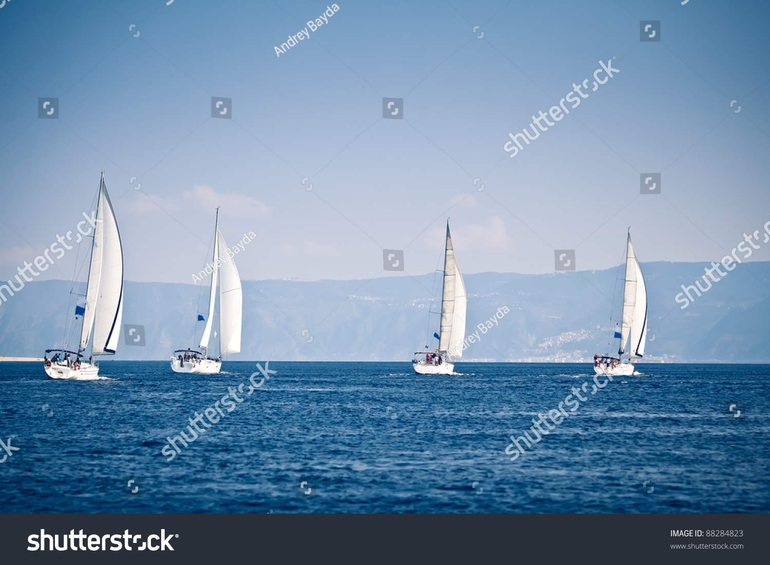 Sailing ship yachts with white sails in a row