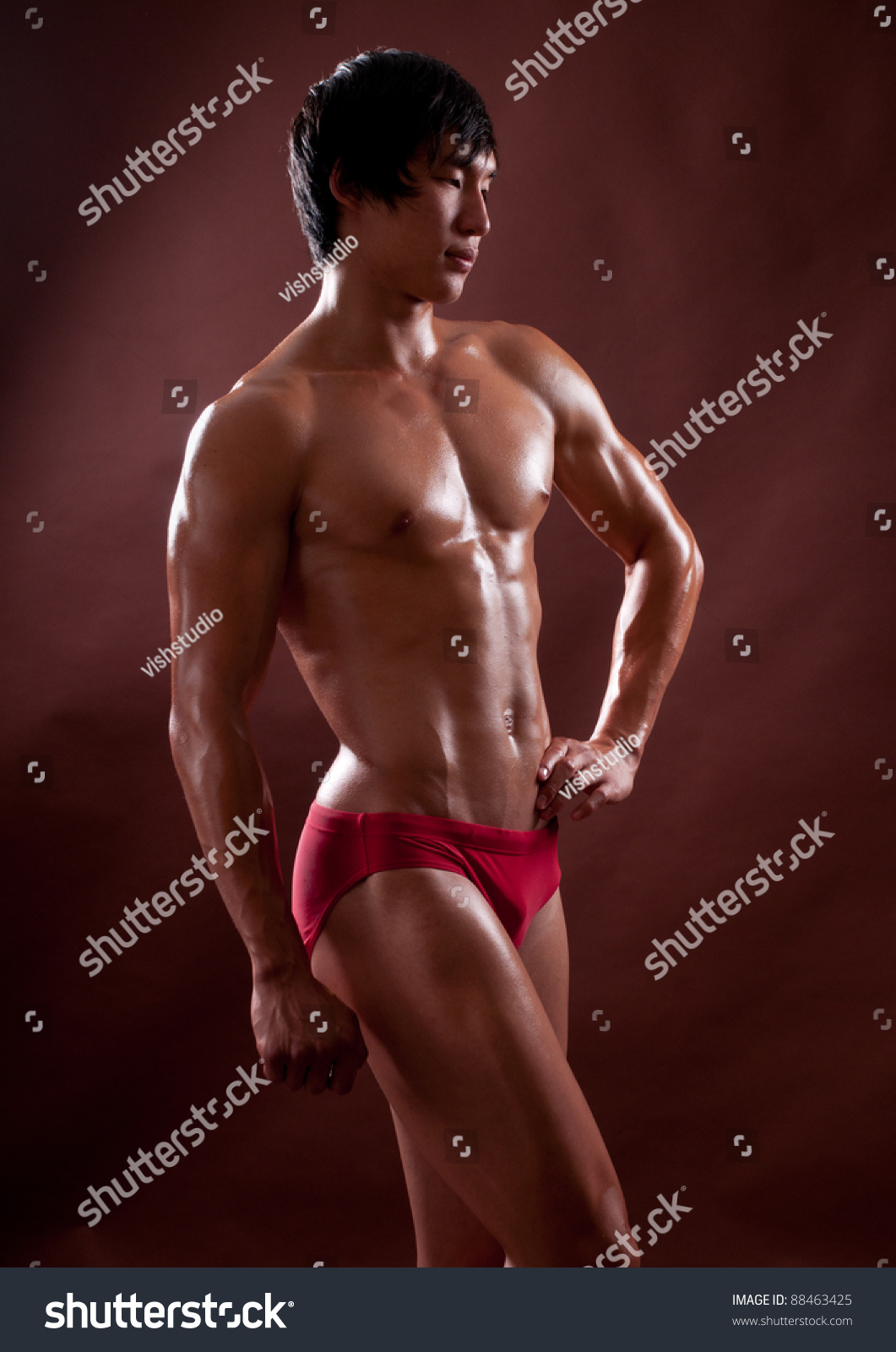 Young korean bodybuilder posing in studio