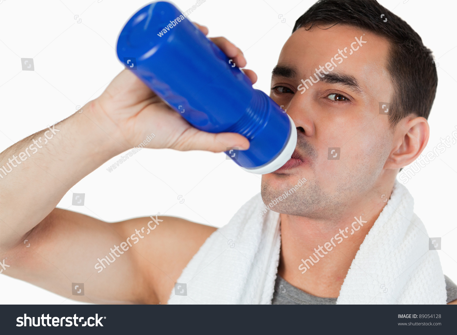 Close up of young man drinking water after workout against a white background