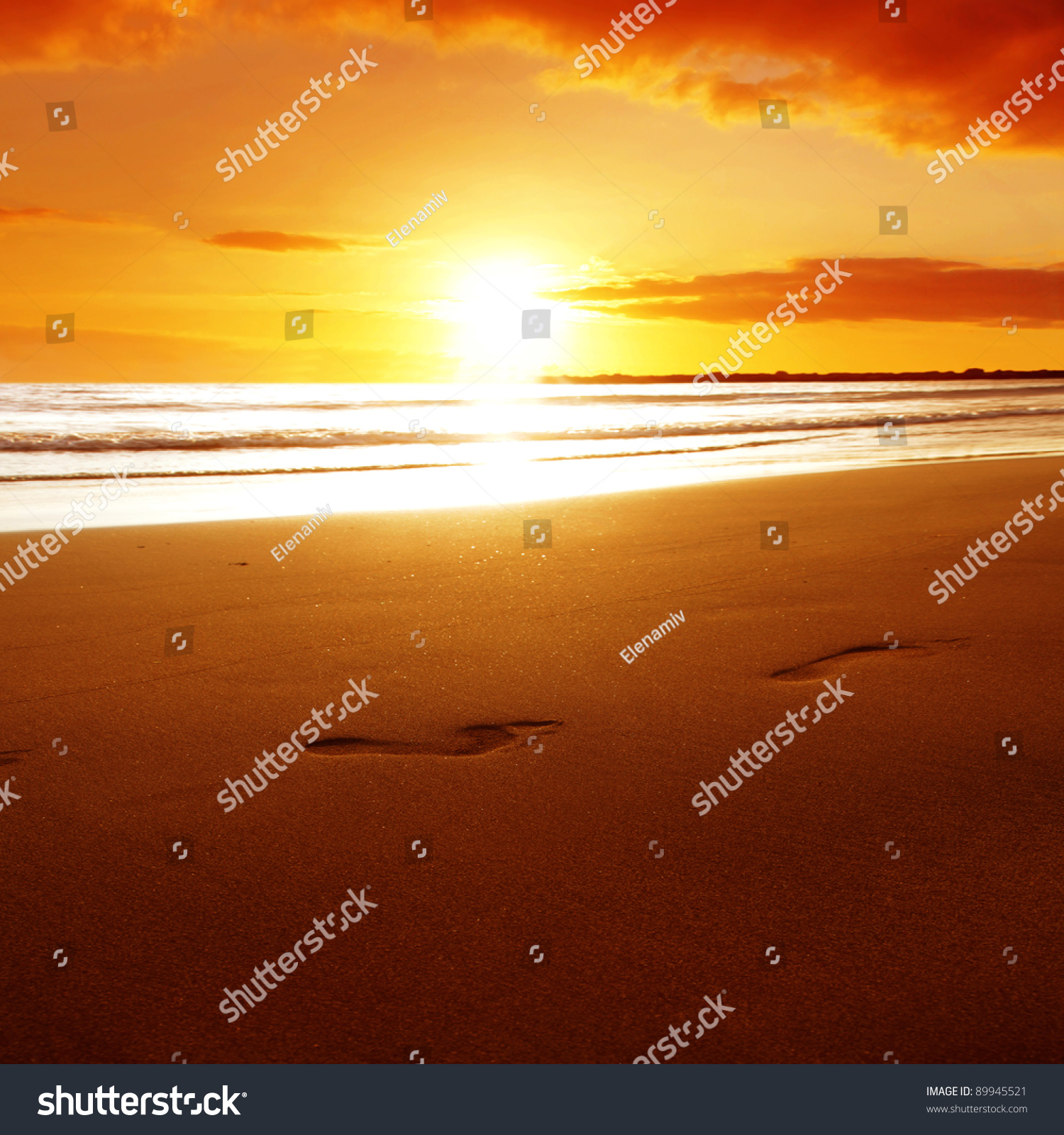Footprints on the beach at sunset.