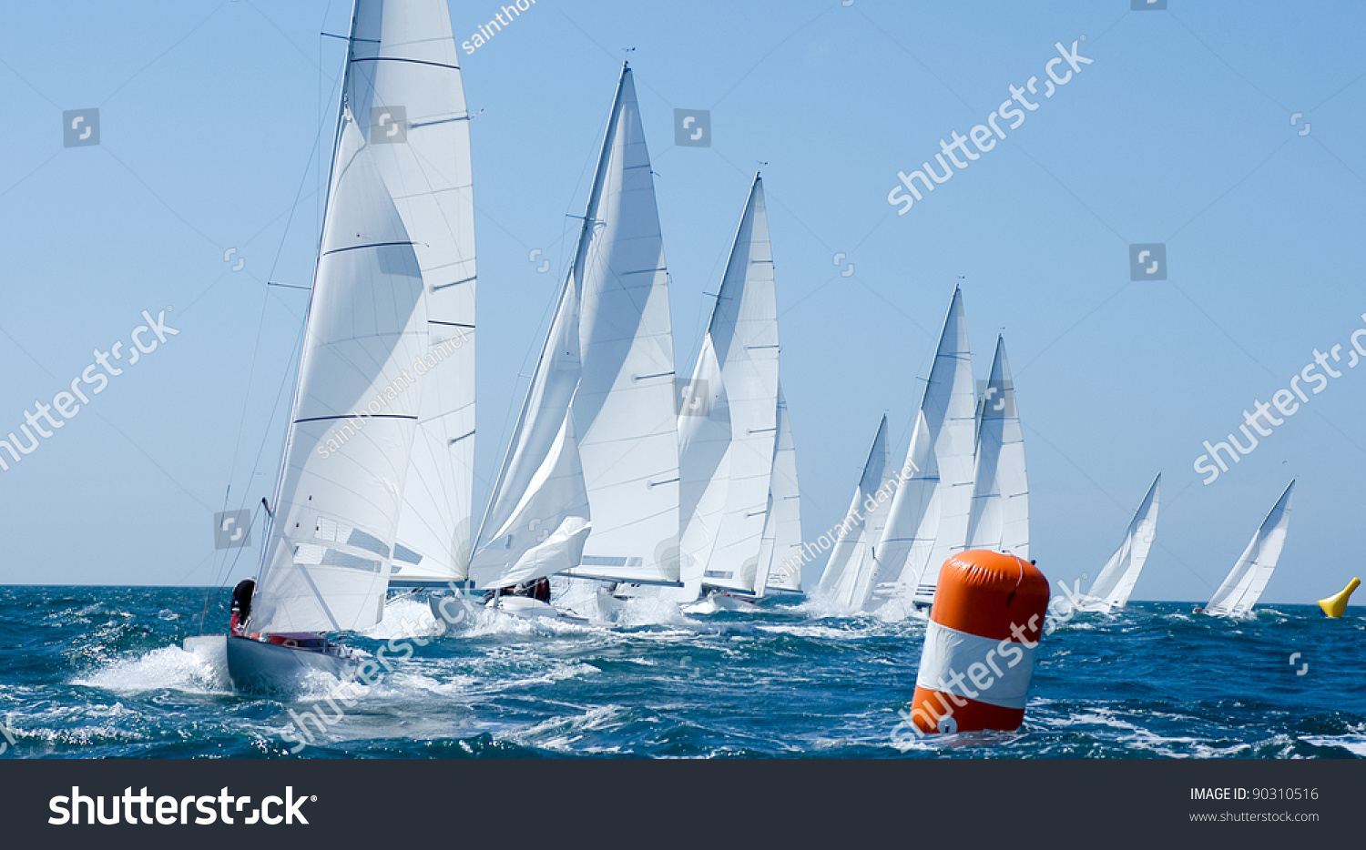group of dragon yacht sail in regatta near a  buoy