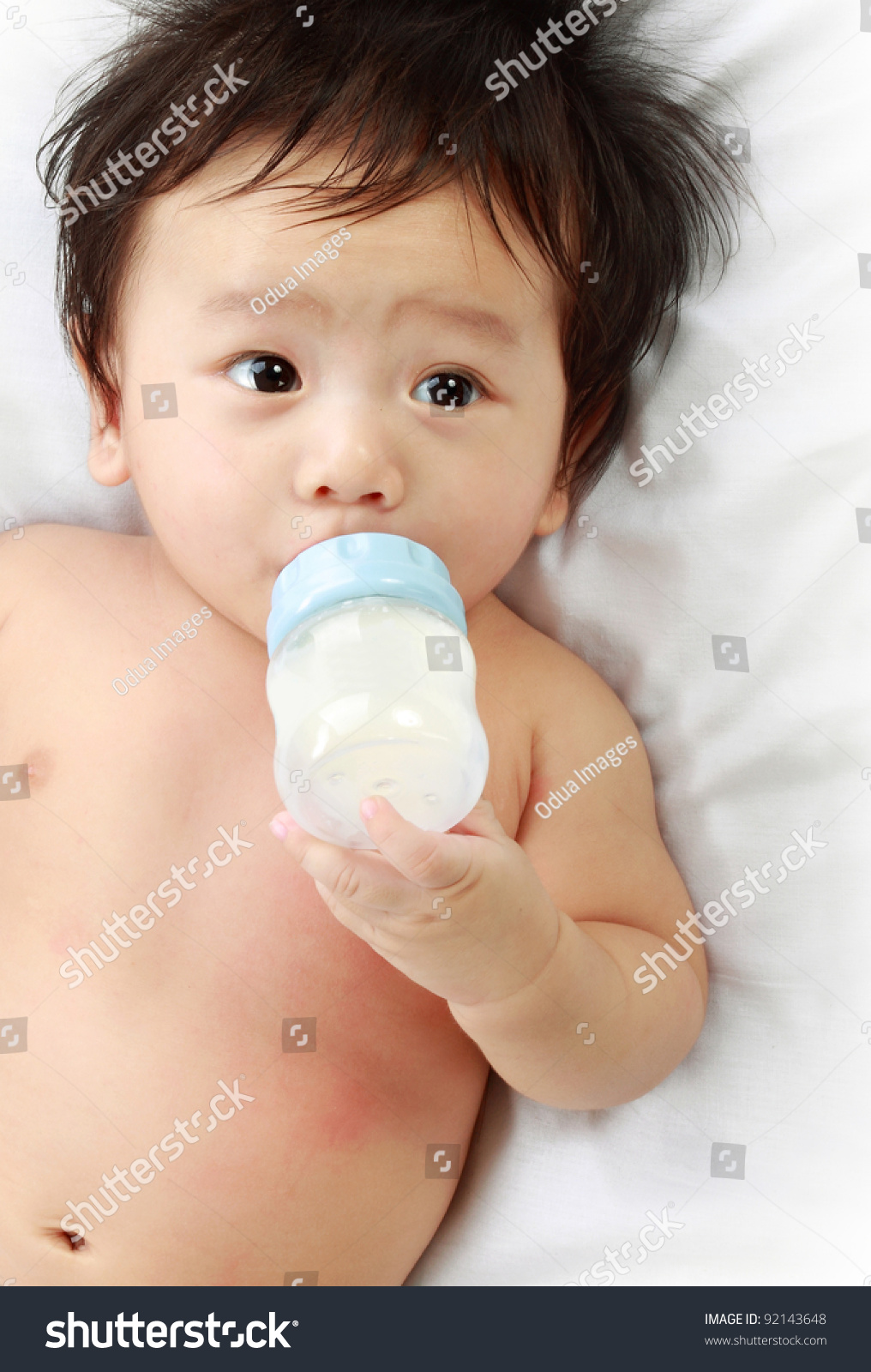 Little baby drinking milk from bottle.