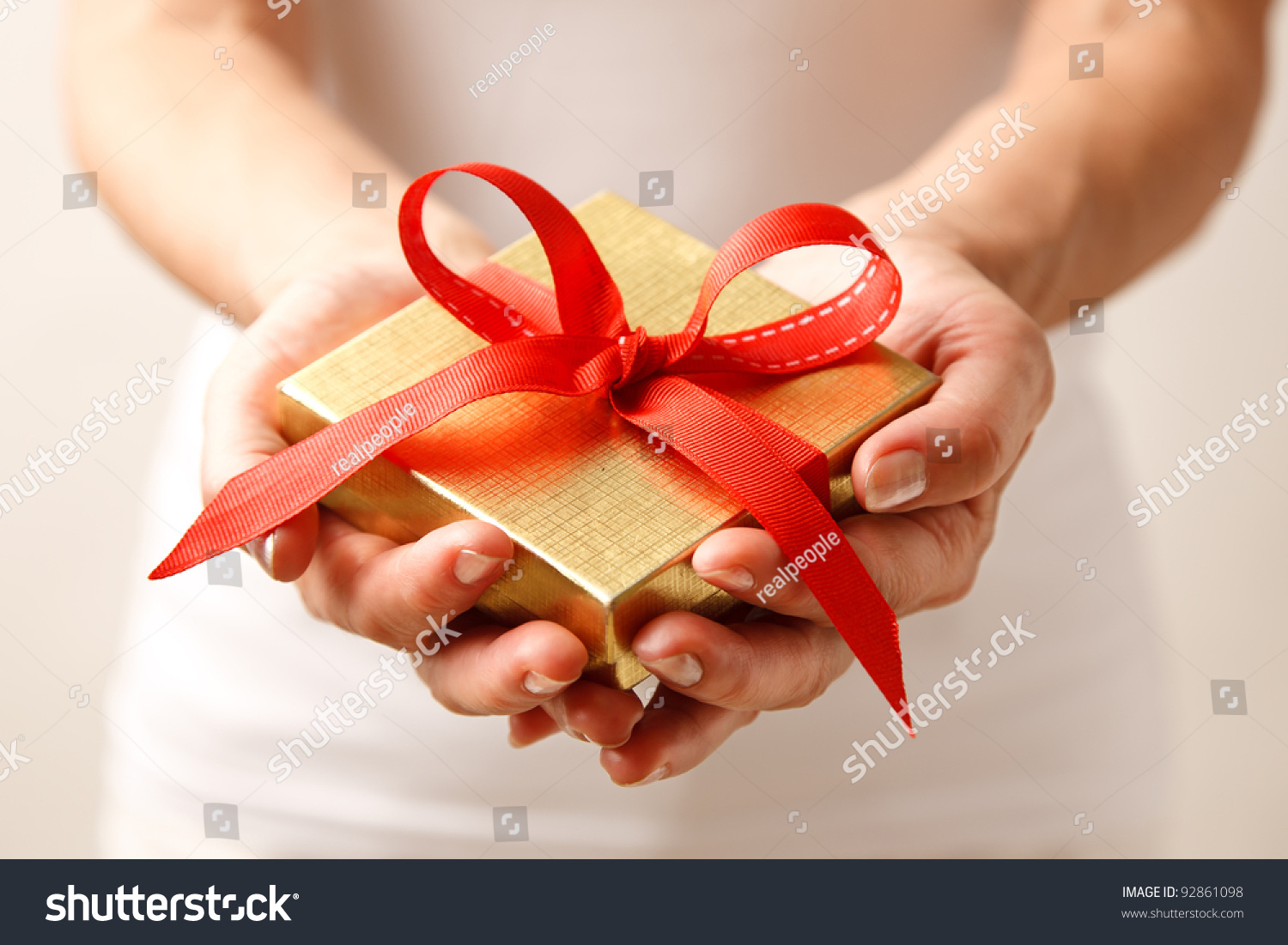 Woman holding a gift box in a gesture of giving.