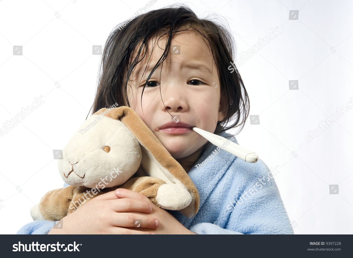 A young girl is sick and having her temperature taken.