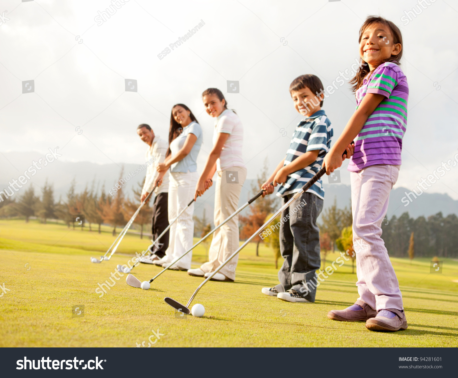 Golf players of all ages practicing to hit the ball at the course