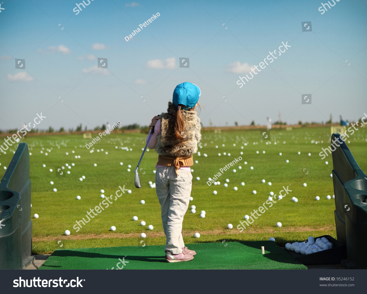 Little girl swinging golf club  rear view