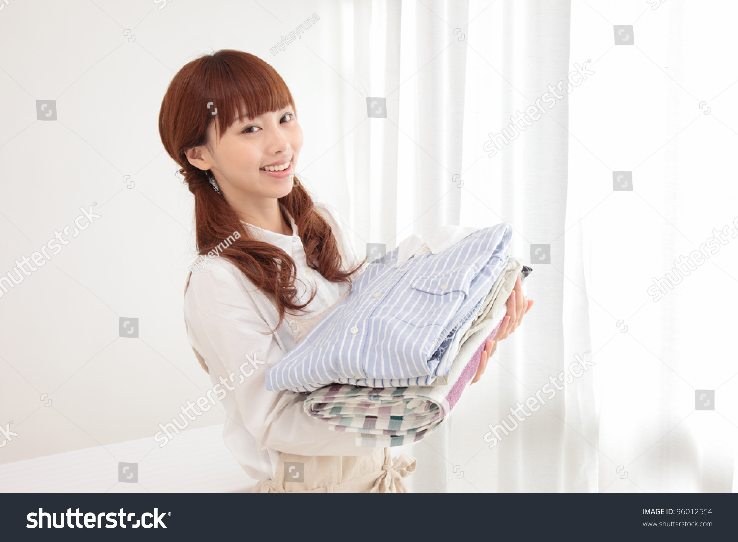 Beautiful young Asian woman at the window with the laundry