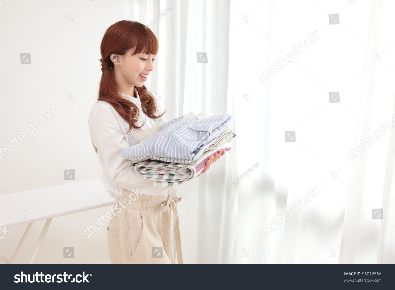 Beautiful young Asian woman at the window with the laundry
