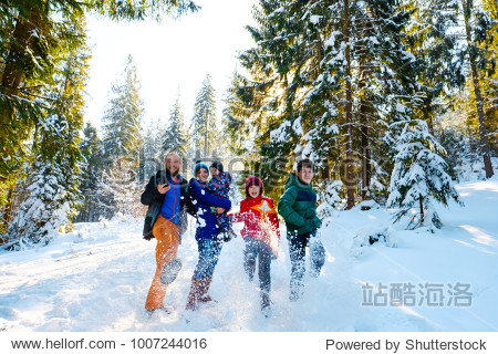 Happy people having fun and playing with snow outdoors in winter nature. Family Christmas holiday walk in a snowy park on ski resort with children. Winter vacation in mountains with kids.