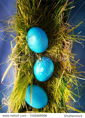 vertical row of blue collored easter eggs located on the soft